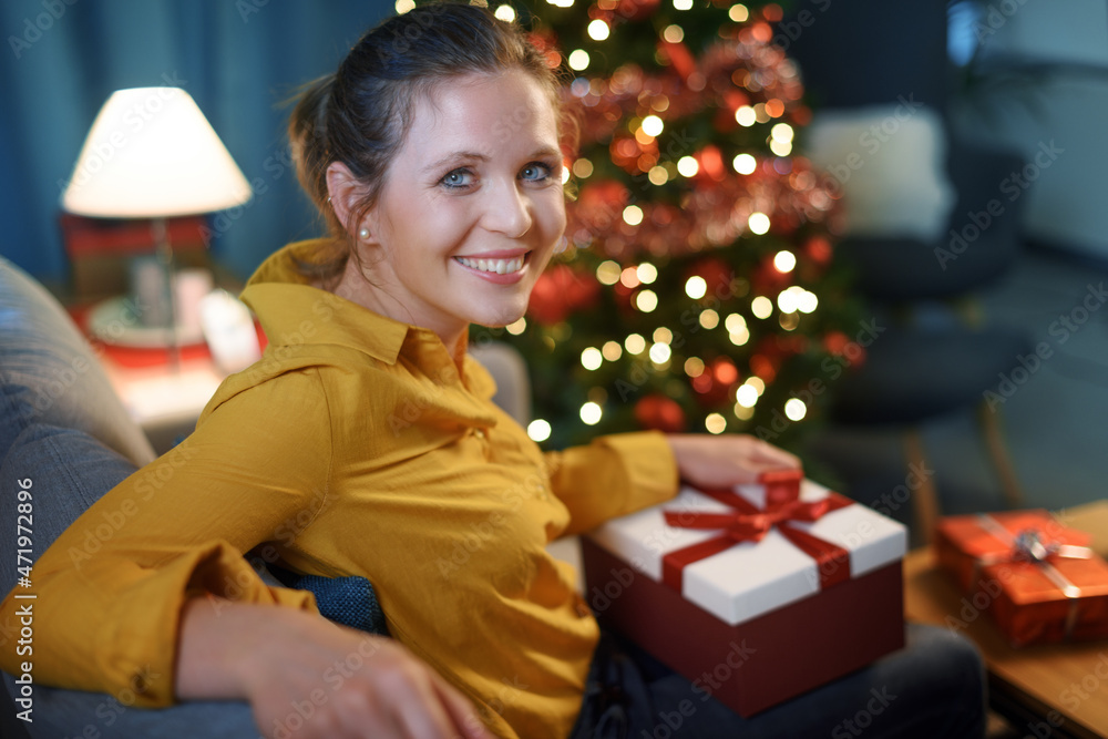 Happy woman holding a Christmas gift Happy woman holding a Christmas gift