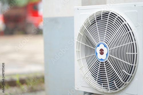 The air conditioner fan on the outer wall of the building for cooling.