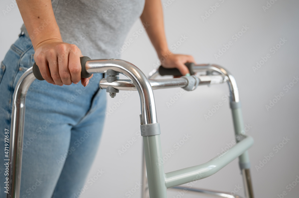 A woman is walking with a walker on a white background