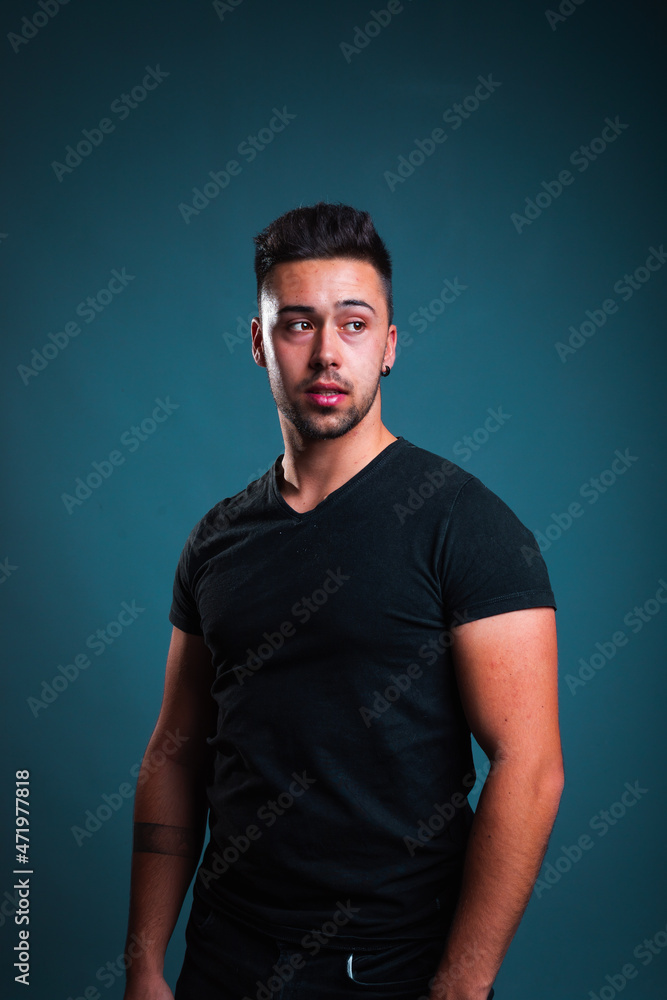 Young caucasian man portrait in a photography studio with a blue background. Young caucasian man portrait in a photography studio with a blue background.