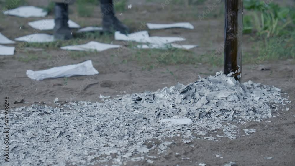 Falling ash of white paper sheets on ground Falling ash of white paper sheets on ground