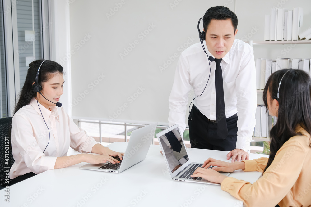 manager asia man teaching to asian woman working call center operator with headset in office or workplace