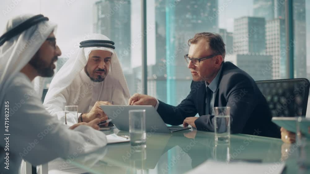 International Business Consultant Advices on Diversification of Investment Portfolio to Successful Arab Company Owners. Multicultural Meeting in Modern Office Between European and Emirati Businessman International Business Consultant Advices on Diversification of Investment Portfolio to Successful Arab Company Owners. Multicultural Meeting in Modern Office Between European and Emirati Businessman