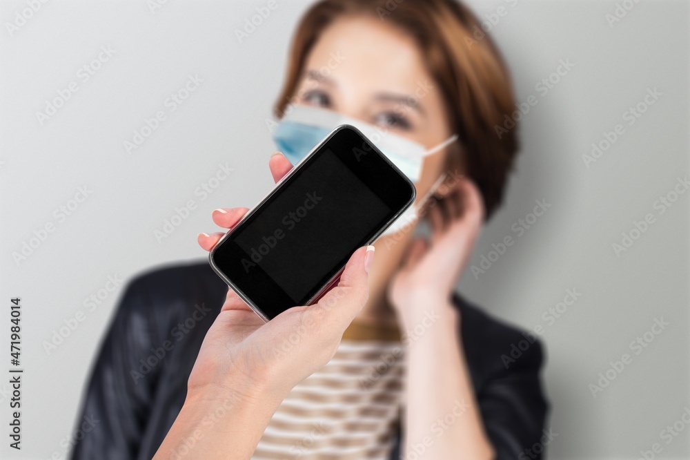 Covid-19 Health Passport. Traveler woman wearing a face mask holding a blank screen smartphone Covid-19 Health Passport. Traveler woman wearing a face mask holding a blank screen smartphone