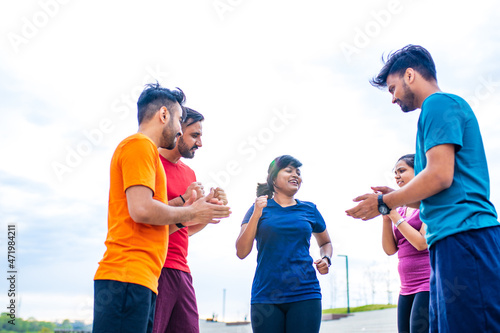four indian people warming up outdoors in sport wear morning time urban