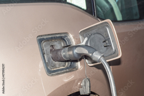 Element of an electric car connected to a charging plug, frontal view