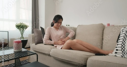 Young woman having a stomachache on sofa,4K photo