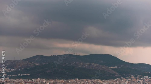 Dramatic rain clouds forming above hill with telecom antennas outside Athens, timelapse photo