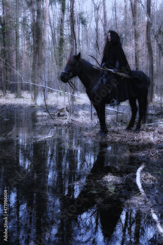 romantic picture of a beautiful rider on a horse in the woods by a small lake © michal