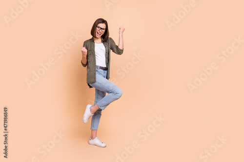 Photography Photo of funny astonished lady celebrate victory wear specs khaki shirt isolated