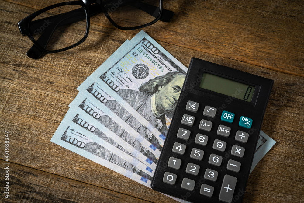 A calculator and dollar banknote. A calculator and dollar banknote.