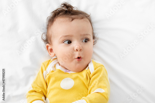 Close up of funny baby girl with surprised face photo