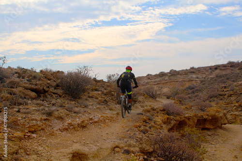 Mountain Bike cyclist riding single track in an arid canyon (Tenerife, Spain)