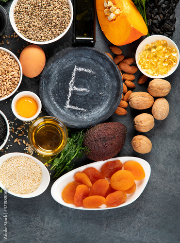 Foods high in vitamin E on dark background.