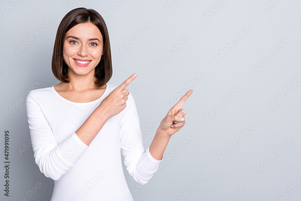 Photo of lovely bob hairdo millennial lady show empty space wear white shirt isolated on grey color background Photo of lovely bob hairdo millennial lady show empty space wear white shirt isolated on grey color background