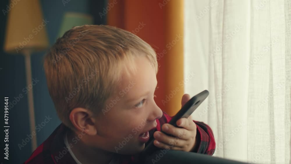 Smiling little boy is talking via video call sitting in a cozy, home-like atmosphere Smiling little boy is talking via video call sitting in a cozy, home-like atmosphere