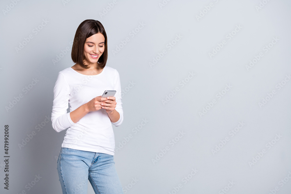 Photo of pretty bob hairstyle young lady write telephone wear shirt jeans isolated on grey color background Photo of pretty bob hairstyle young lady write telephone wear shirt jeans isolated on grey color background