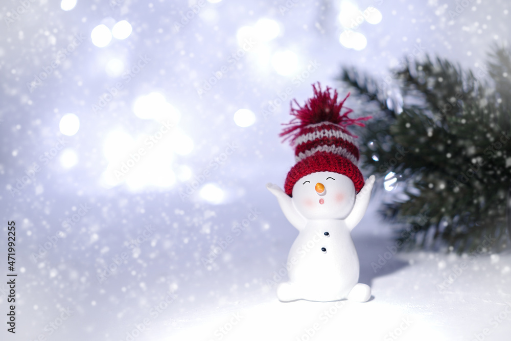 Happy snowman standing in a snowy winter day. Happy snowman standing in a winter Christmas landscape. Merry christmas and happy new year greeting card. Funny snowman in a hat on a snowy background.