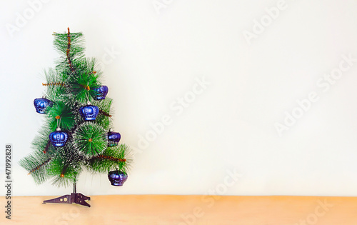 christmas tree decorated with blue toys on a light background