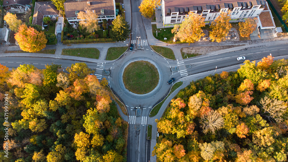Top view of roundabout street with cars in a German city with autumn trees - obrazy, fototapety, plakaty 
