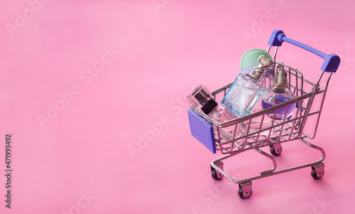 Miniature supermarket trolley perfume bottles, perfume shop seasonal sale, copy space for text