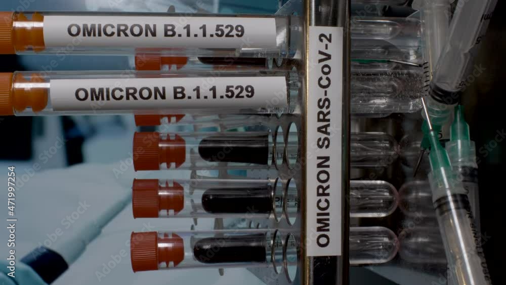 A close up vertical video of medical samples labelled Omicron B.1.1.529 being placed in to a laboratory rack at a research facility, the new strain of carona virus A close up vertical video of medical samples labelled Omicron B.1.1.529 being placed in to a laboratory rack at a research facility, the new strain of carona virus