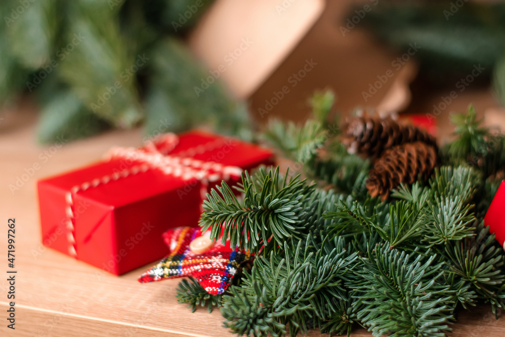 Packing craft paper, fir branches, red gift boxes and fir decorations on the table.The process of creating a creative Christmas bouquet.New Year and Christmas concept.Selective focus. Packing craft paper, fir branches, red gift boxes and fir decorations on the table.The process of creating a creative Christmas bouquet.New Year and Christmas concept.Selective focus.