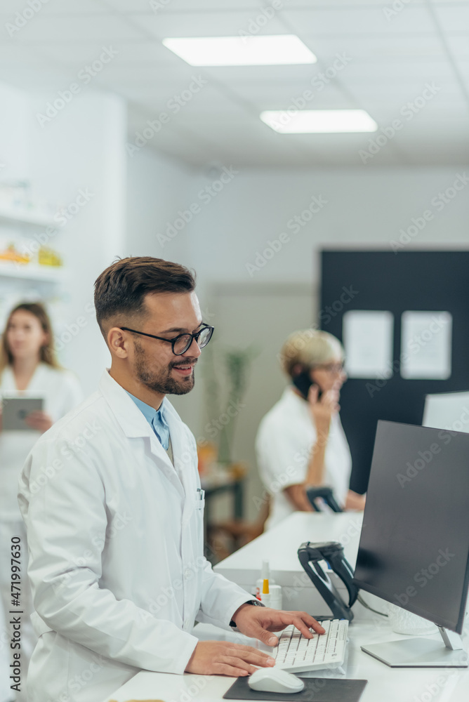 Male pharmacist wearing eyeglasses and a coat working at a pharmacy Male pharmacist wearing eyeglasses and a coat working at a pharmacy