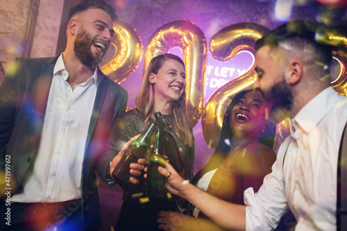 Happy group of friends celebrate New Year's Eve while dancing in the club