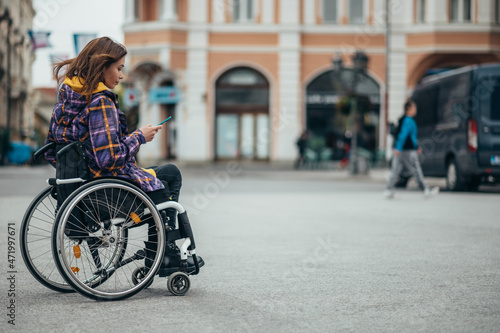 Fototapeta Naklejka Na Ścianę i Meble -  Woman with disability using a smartphone while out in the city