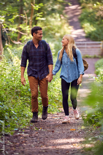 Wall Mural Loving Couple In Countryside Hiking Along Path Through Forest Together Holding H