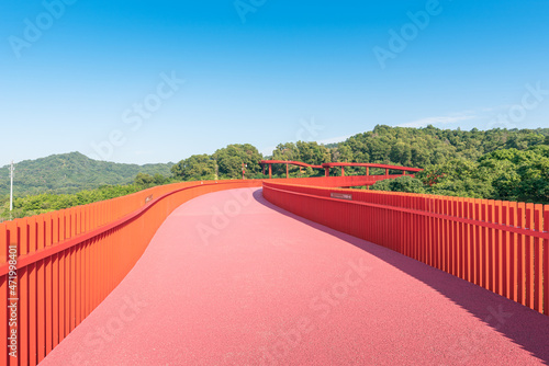 An outdoor park with a red bridge in Shenzhen, China photo