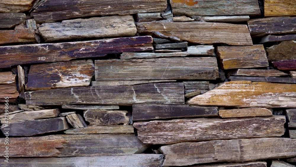 Stone wall made of multi-colored layered natural sandstone Stone wall made of multi-colored layered natural sandstone