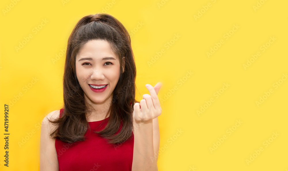 Asian beautiful woman make mini heart gesturing and express happiness and smiling for valentine's day. a Love concept Asian beautiful woman make mini heart gesturing and express happiness and smiling for valentine's day. a Love concept