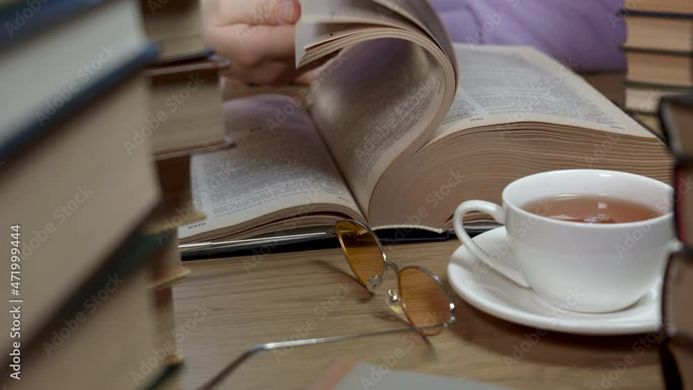 Female hand flipping through the pages of a book, closeup Female hand flipping through the pages of a book, closeup