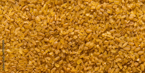 Bulgur - cooked and dried wheat groats, food background 