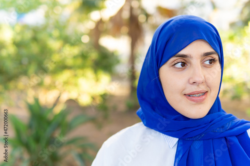 Portrait of a young muslim woman wearing hijab in a park