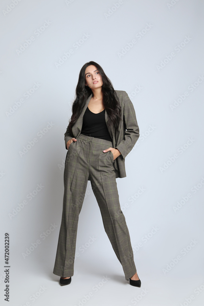 Full length portrait of beautiful woman in formal suit on light background. Business attire Full length portrait of beautiful woman in formal suit on light background. Business attire