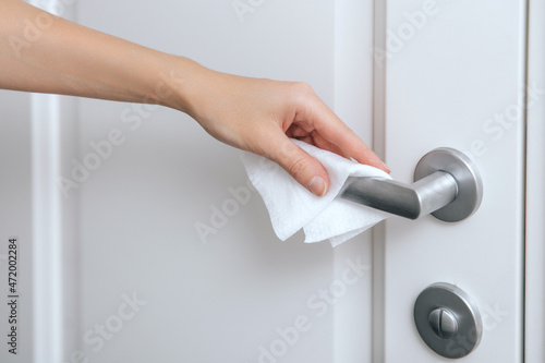 фотографія Cleaning door handles with an antiseptic wet wipe and gloves