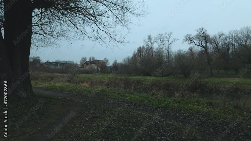The river among the city park. Late autumn, cloudy. Trees without leaves and dried reeds along the banks of the river. Aerial photography. The river among the city park. Late autumn, cloudy. Trees without leaves and dried reeds along the banks of the river. Aerial photography.