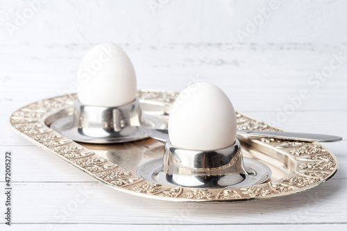 Boiled egg in an egg cup on an old metal breakfast tray
 photo