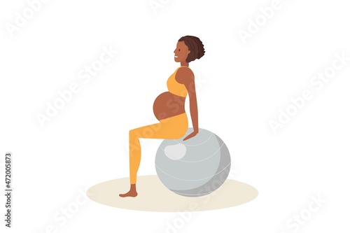 Exercises with fitball for pregnant women. Pregnant African American woman sitting on large gray ball. Woman in sportswear does fitness Women healthy life style concept. Prenatal Exercises