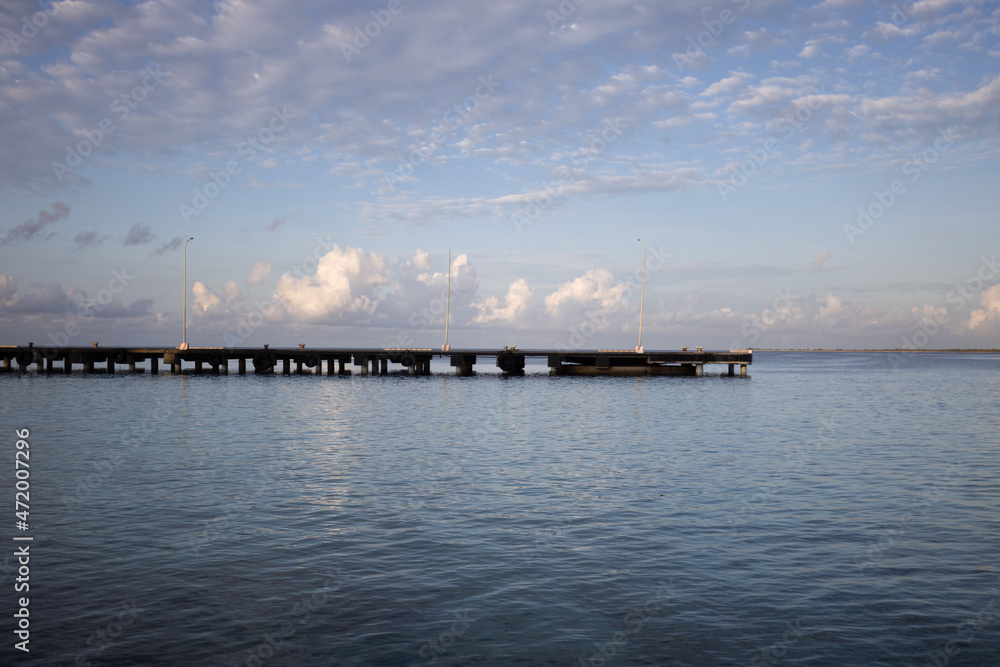 The morning seascape. The pier, the sea and soft clouds above it.