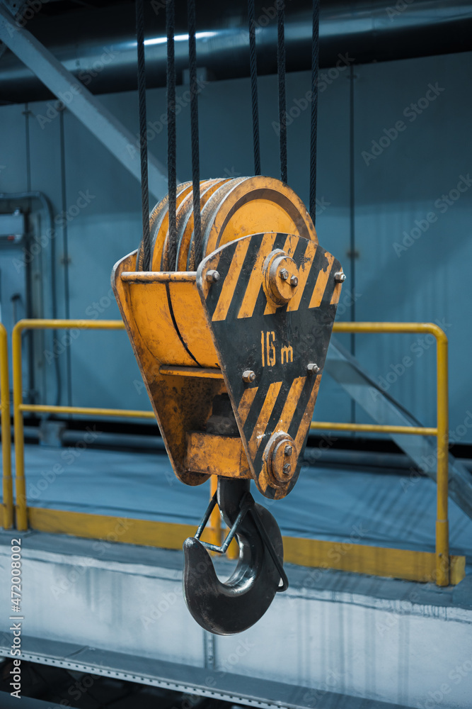 yellow crane hook on a construction site yellow crane hook on a construction site