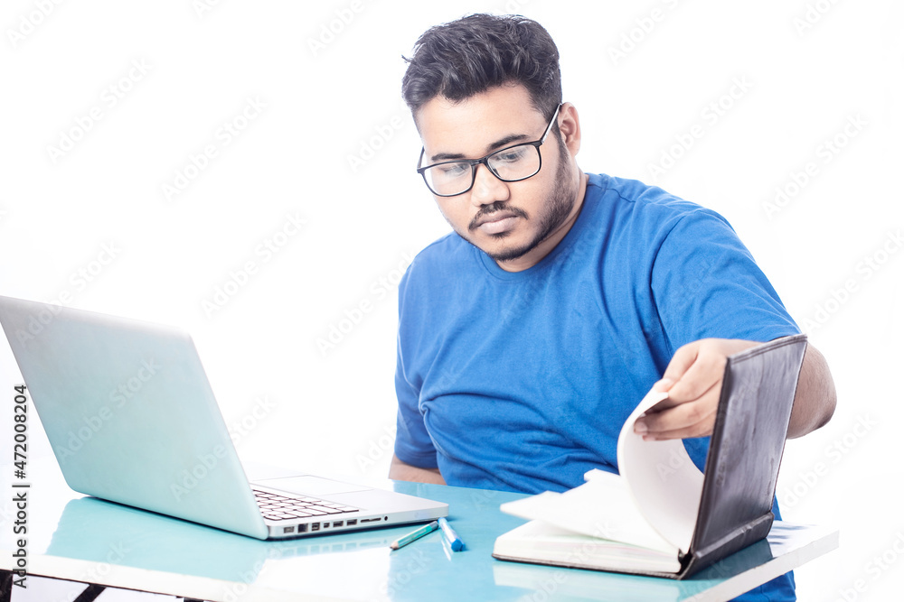 serious business man working on laptop and searching something on a notebook diary serious business man working on laptop and searching something on a notebook diary