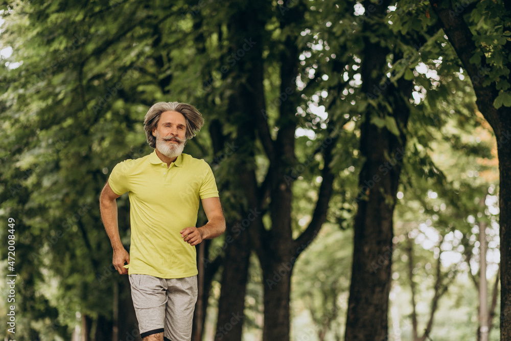 Middle aged man jogging in forest Middle aged man jogging in forest