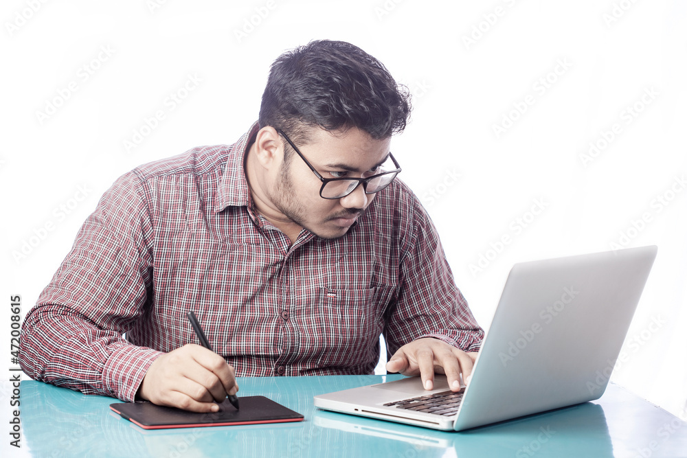 3d artist drawing with digital graphic tablet and stylus pen on laptop looking over eyeglass 3d artist drawing with digital graphic tablet and stylus pen on laptop looking over eyeglass