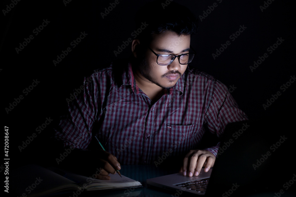 dedicated student studying online course at late night using laptop