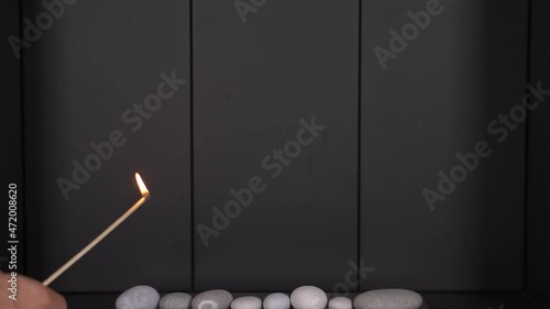 light a match electric home gas fireplace. fire in the frame light long match. kindle fire. home electric fireplace on gas. close-up slowly. Hands holding matchbox while striking Cigar match photo