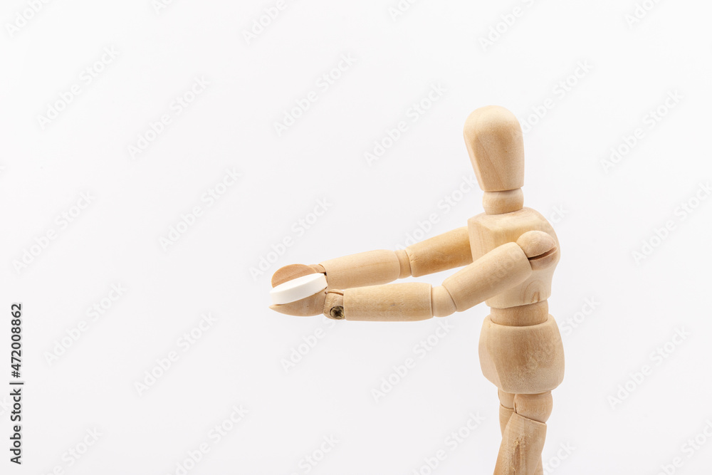 Wooden mannequin with pills on white background. Concept of pharmaceuticals and supplements. Wooden mannequin with pills on white background. Concept of pharmaceuticals and supplements.